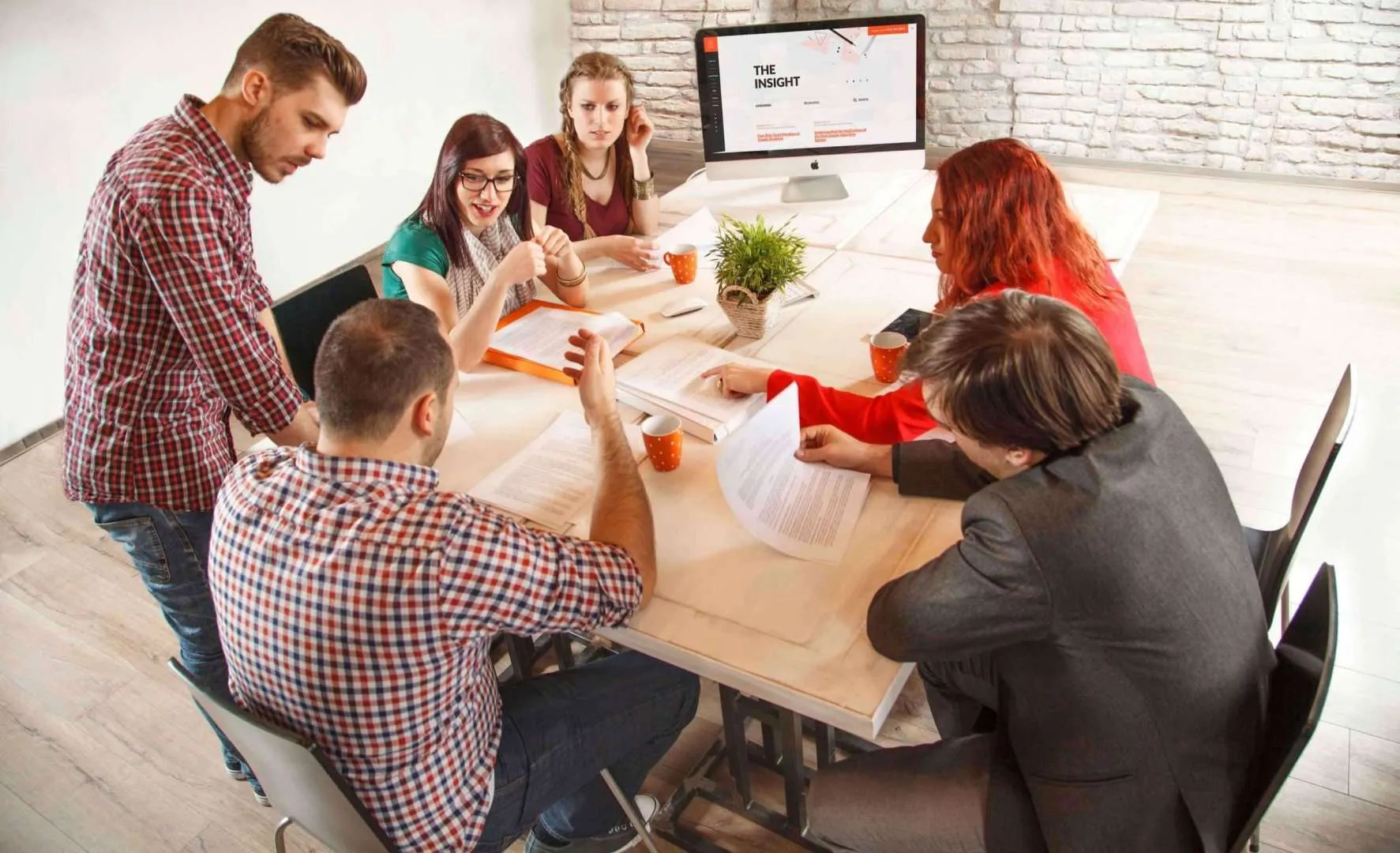 Team meeting in a modern office with a presentation on screen.